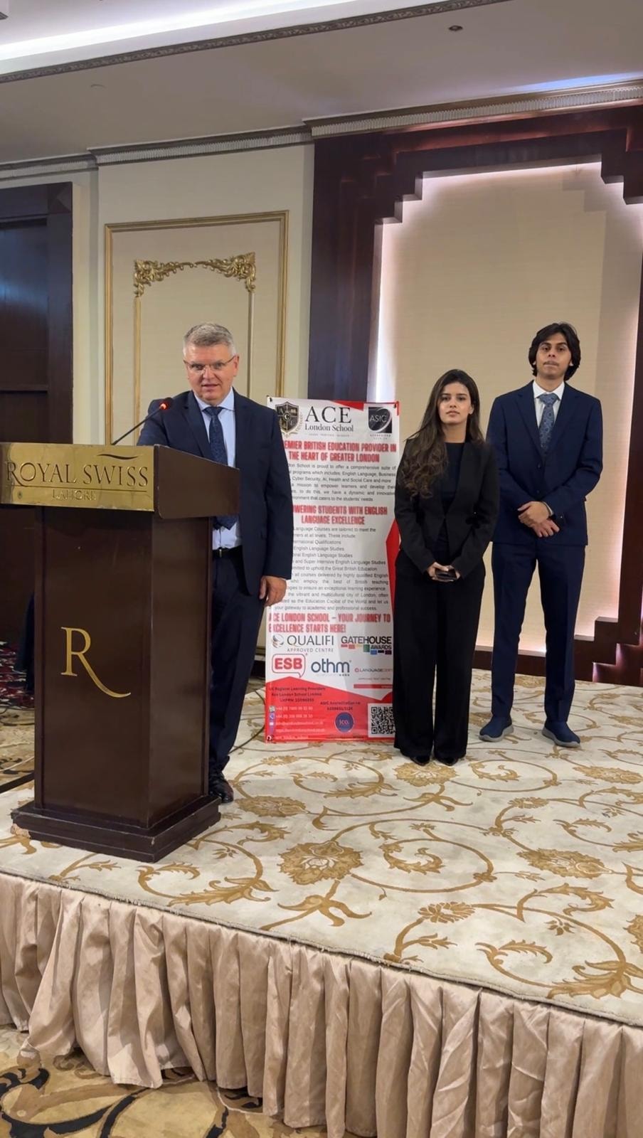 ACE London School Principal presenting at Royal Swiss Hotel podium, Lahore