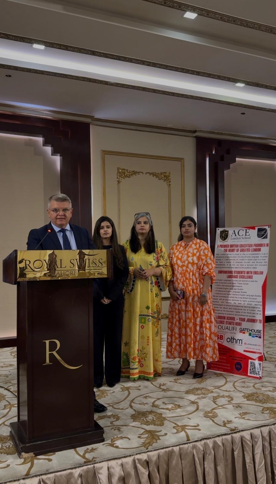 ACE London School Principal at Royal Swiss Lahore podium with ACE and ASIC banner