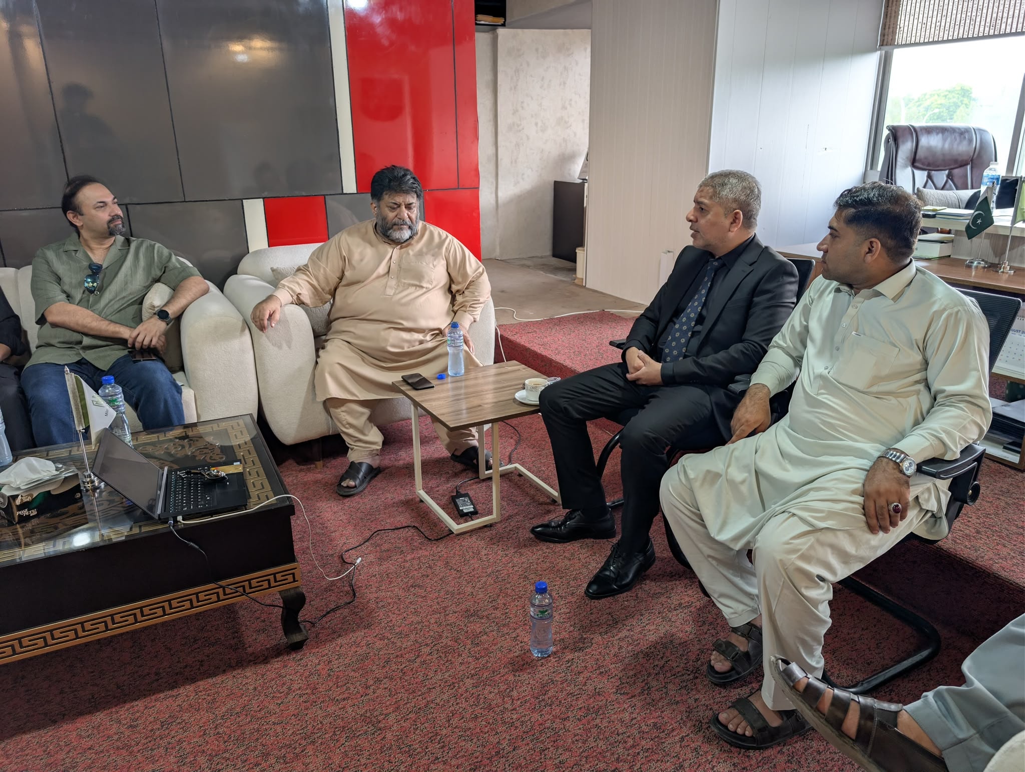 Agents' Conference at Milano Marketing Islamabad — four men in discussion at partner office, Islamabad