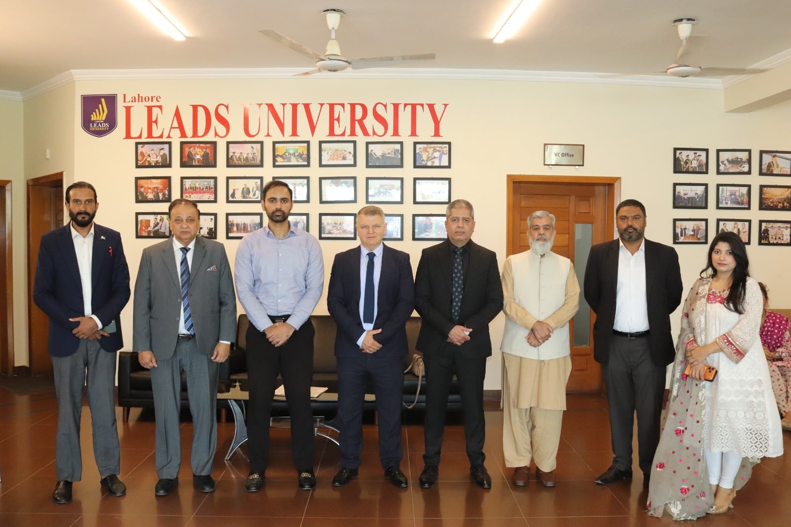 ACE London School delegation group photo at Lahore Leads University reception hall — eight-person team with university officials